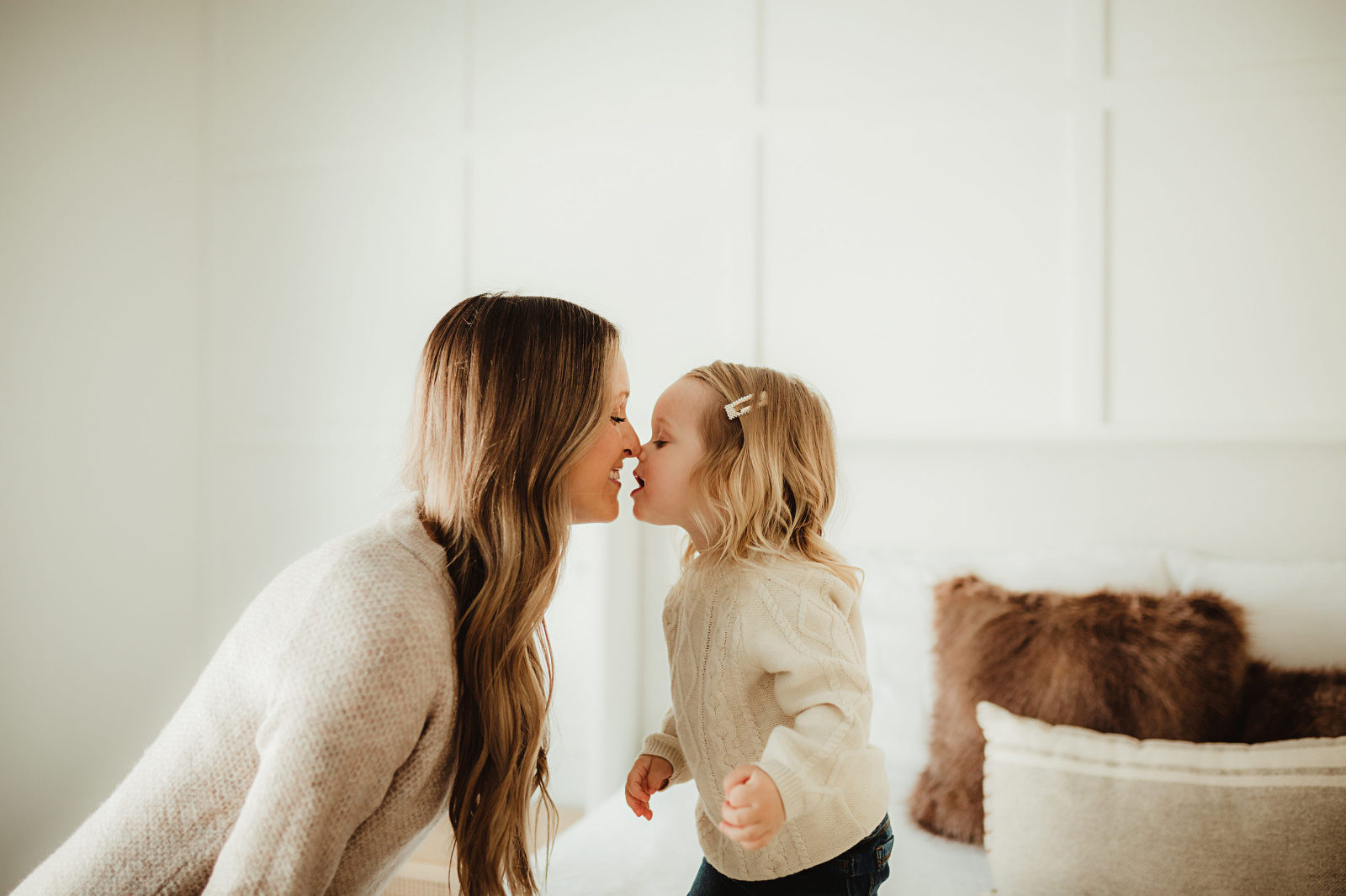 Mom and toddler girl rub noses together for cute picture